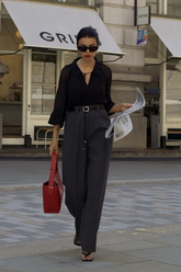 a lady wears a black blouse with grey pants
